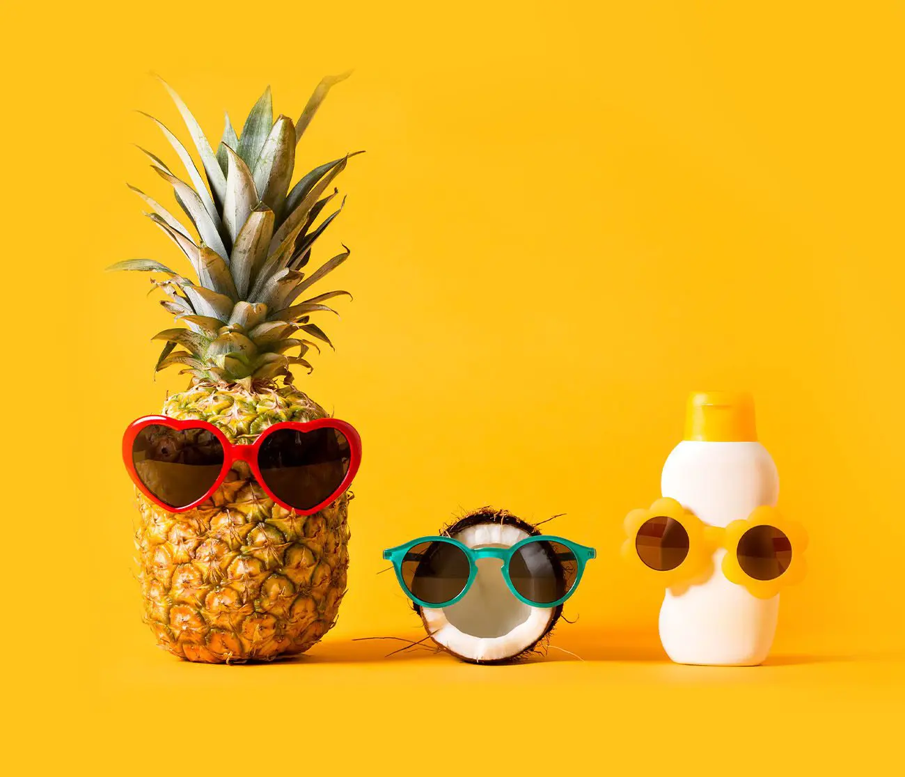 Ananas, Kokosnuss und Sonnencreme mit Sonnenbrille