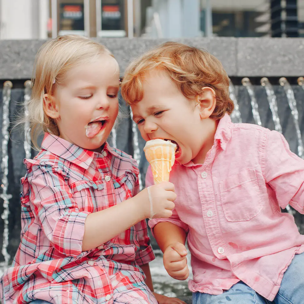Kinder die eine Kugel Eis aus der Waffel essen