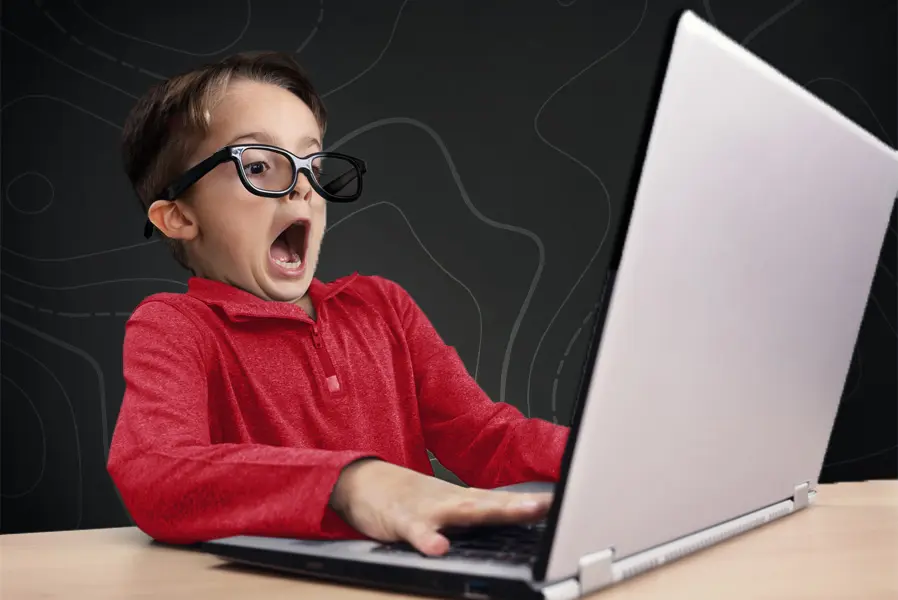 Erschrockenes Kind schaut in einen Laptop